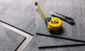 Water droplets on vinyl plank flooring beside wet boots and a folded cleaning cloth